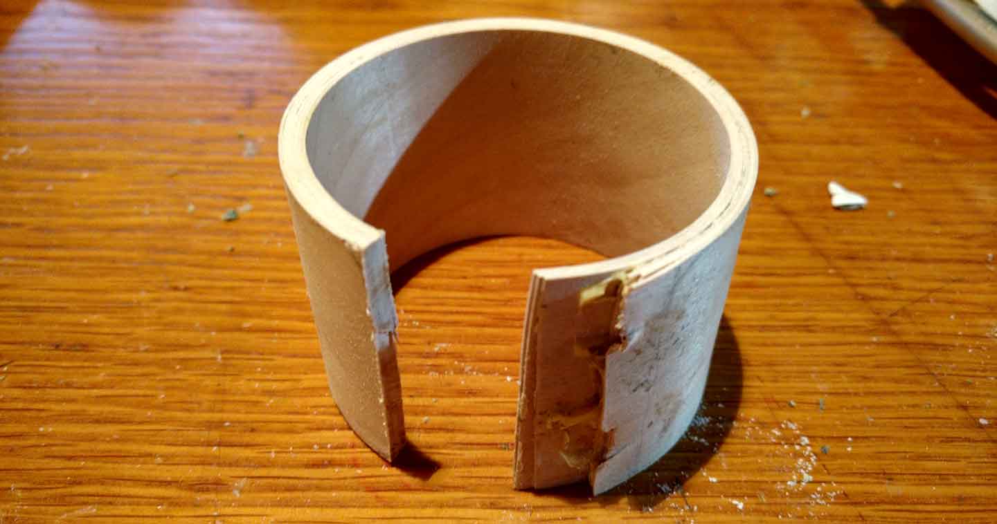 a laminated wood bracelet with one trimmed, the other side shows the lamination